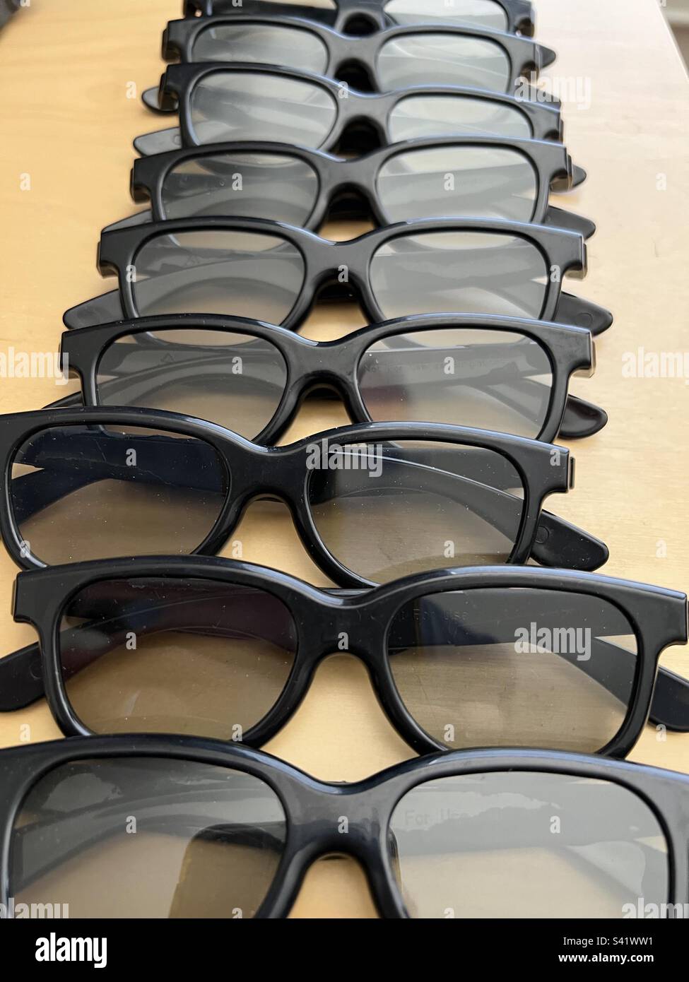 Diversi paia di occhiali 3D neri in plastica per la visione di film o televisione, in confezione di plastica trasparente. Nessun logo o branding visibile Foto Stock