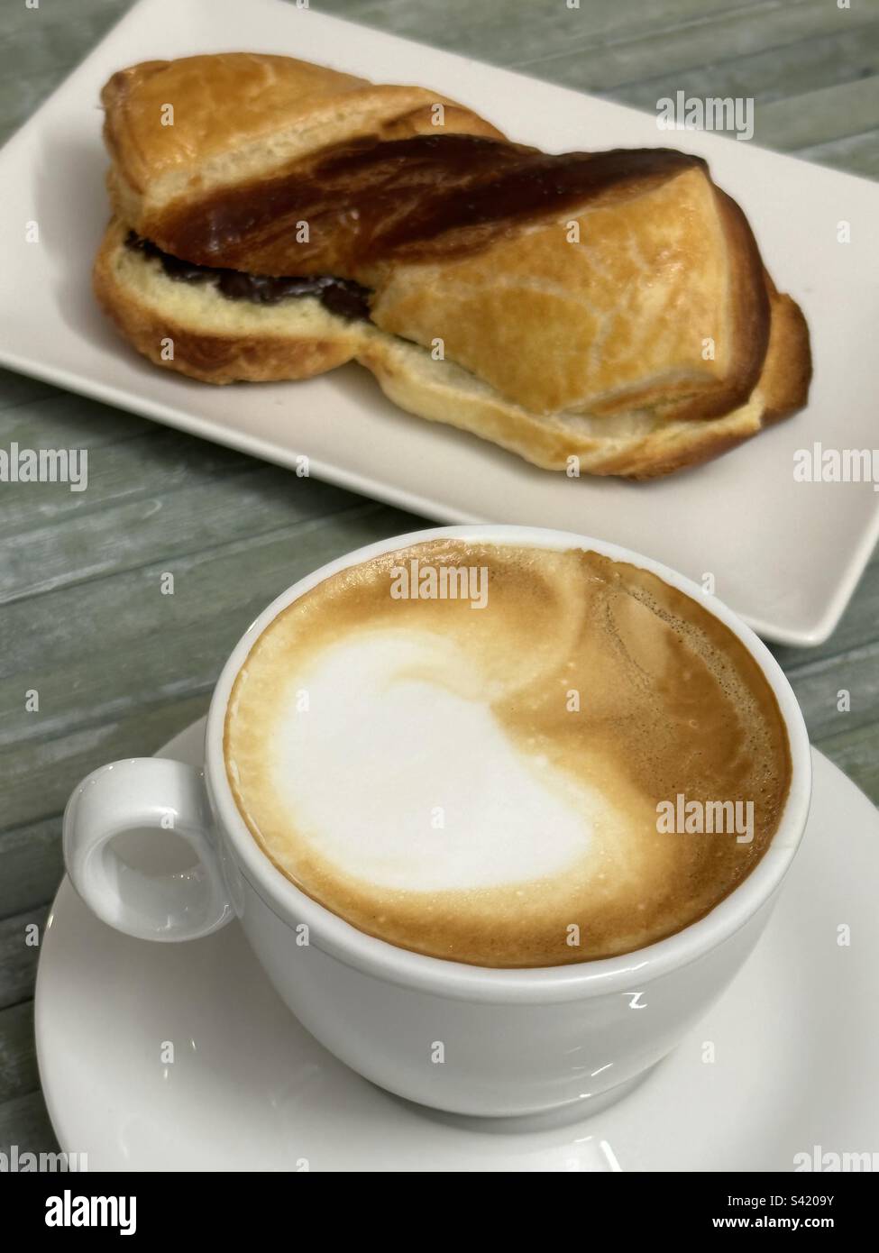 Prima colazione al bar con cappuccino e Kranz, tipico dessert austriaco ripieno di cioccolato Foto Stock