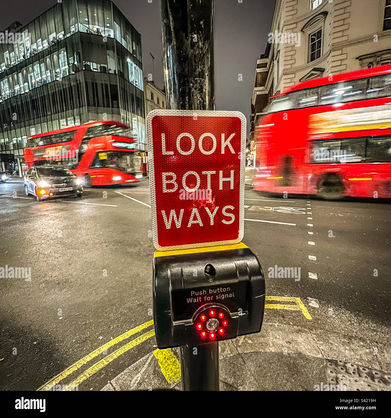 Londra attraversamento pedonale "Look both ways" segno notte Foto Stock