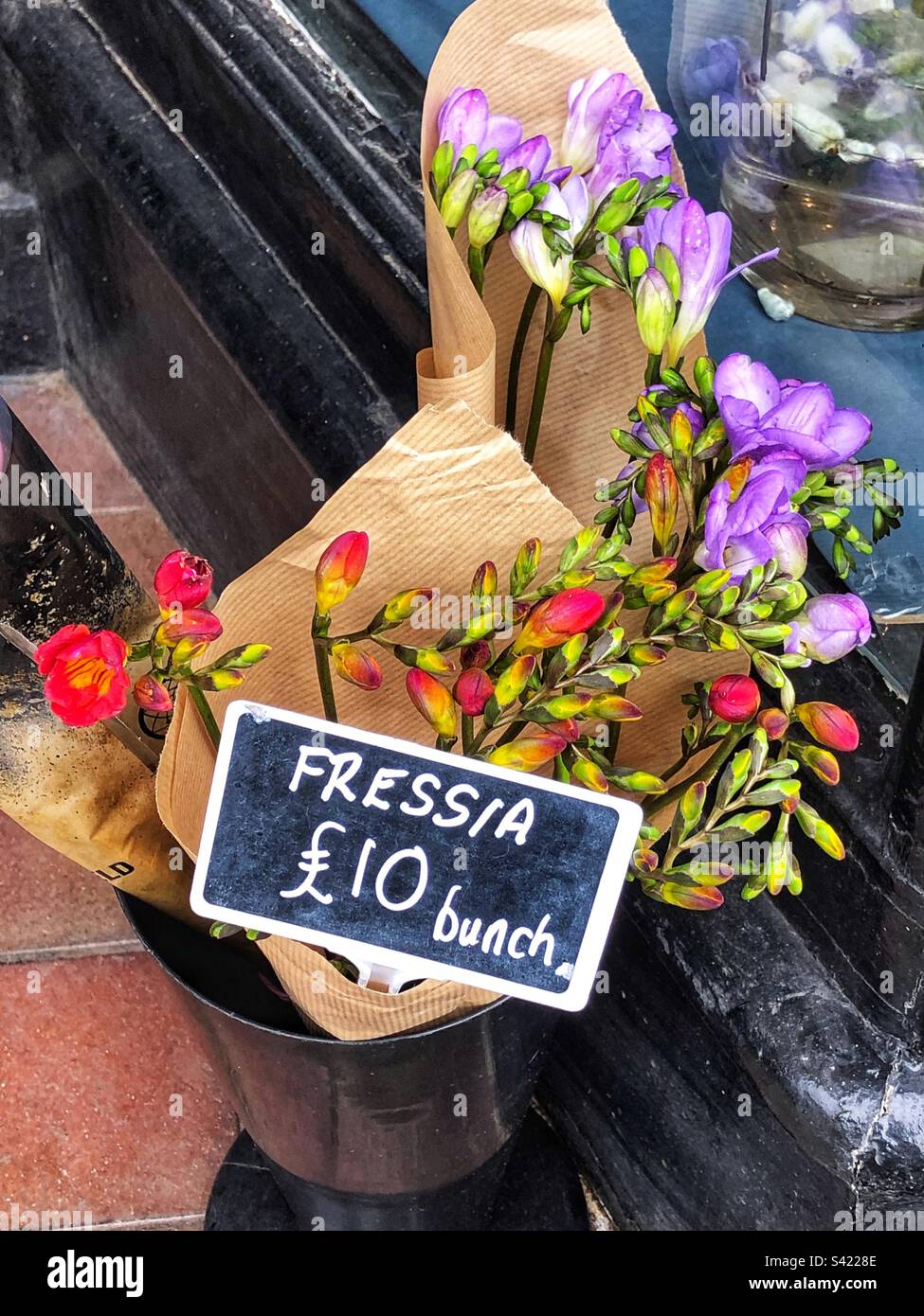 Mazzo di fiori recisi di Fesia prezzo in vendita a fioraio con varietà di fiori rossi e viola Foto Stock