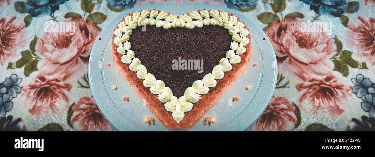 Torta al cioccolato a forma di amore con sfondo floreale marrone e cremoso. SCARICA SUBITO! Foto Stock