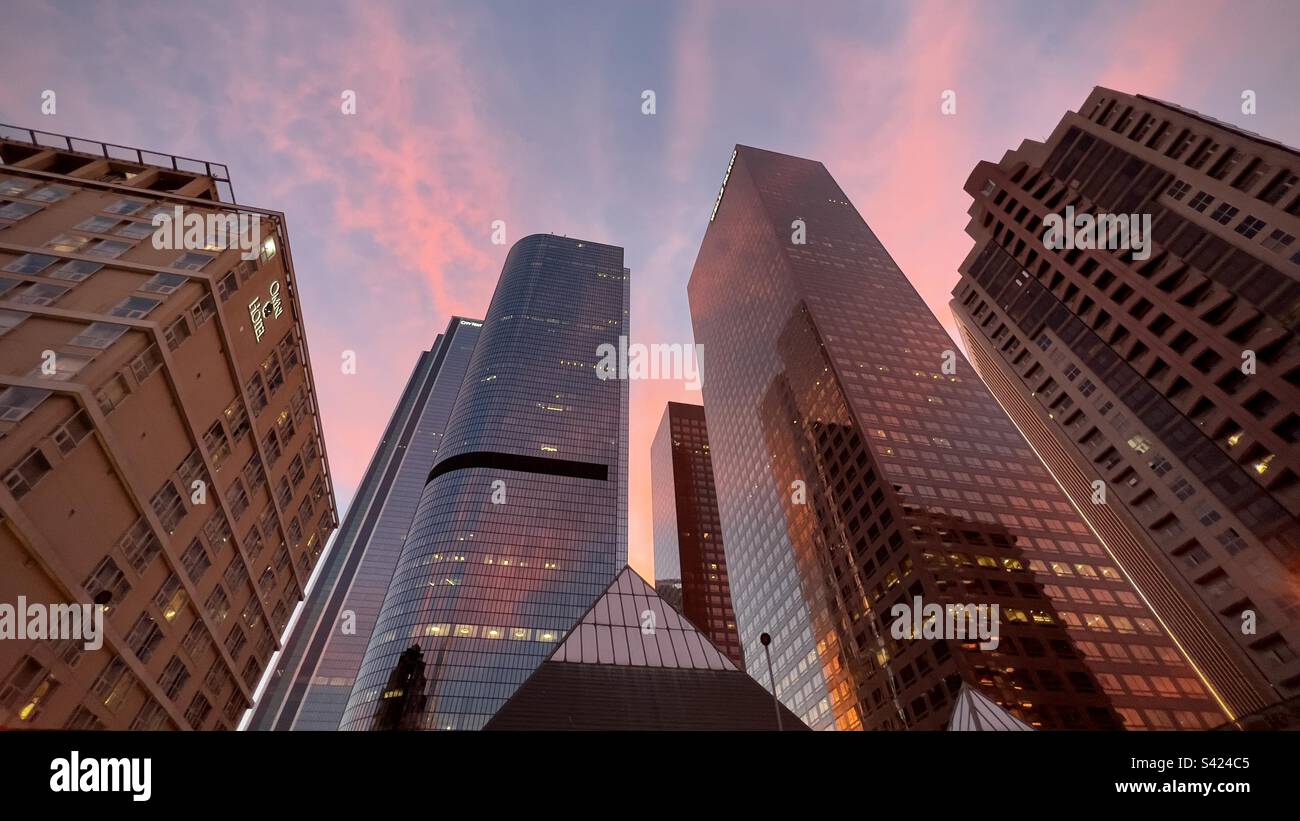 LOS ANGELES, CA, NOVEMBRE 2022: Guarda i grattacieli nel quartiere finanziario del centro al tramonto, con il cielo rosa e viola in alto - Immagine stock catturata con smartphone