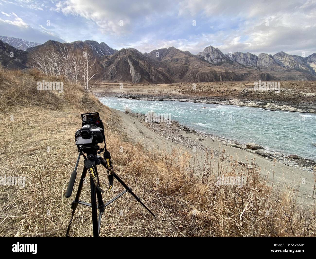 La fotocamera Nikon D750 con filtri di luce quadrati si trova sul bordo della riva del fiume con le montagne ad Altai. Foto Stock