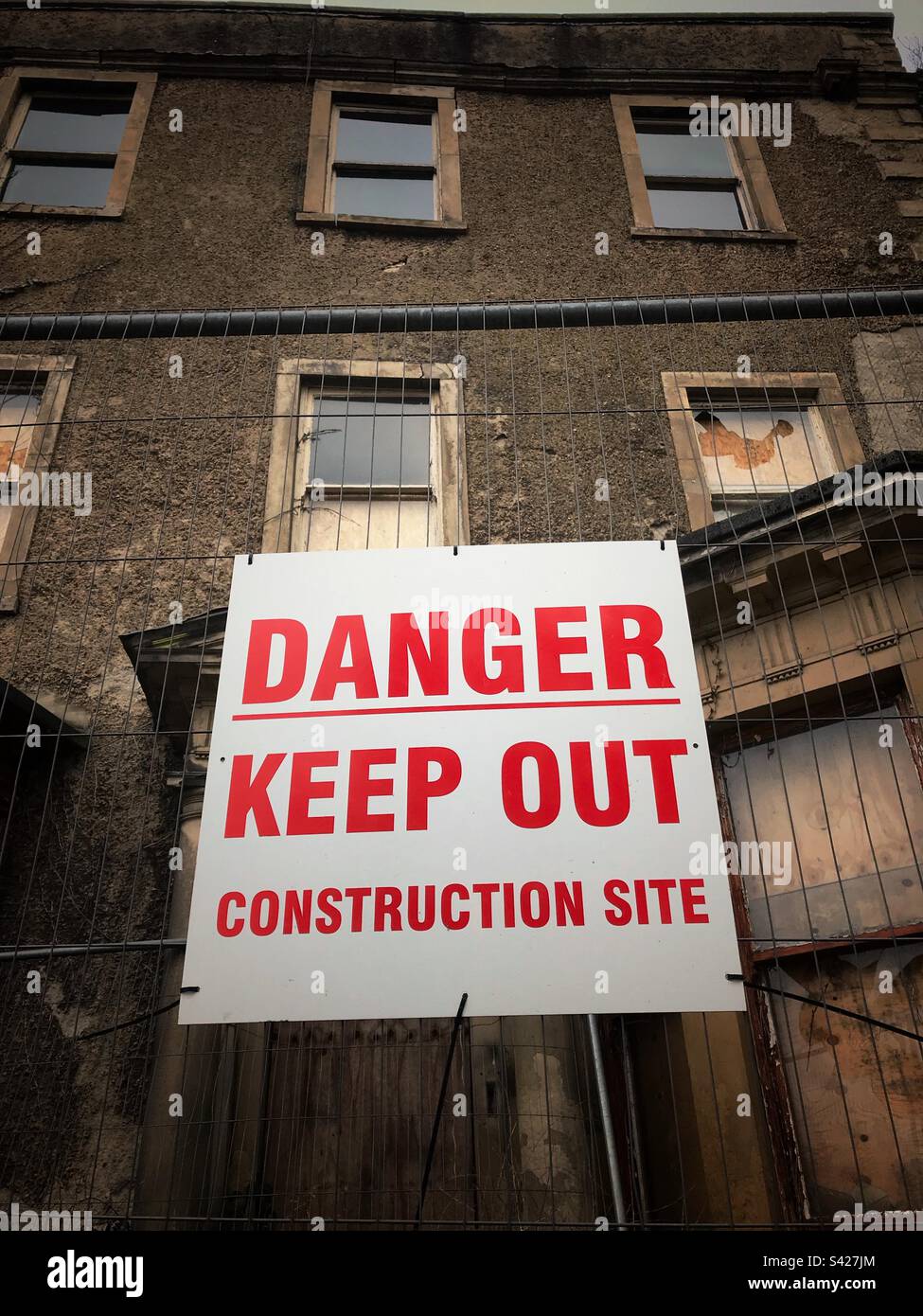 Cartello di divieto di pericolo - edificio vecchio abbandonato in fase di ristrutturazione ora in cantiere nel Regno Unito - Immagine stock catturata con smartphone