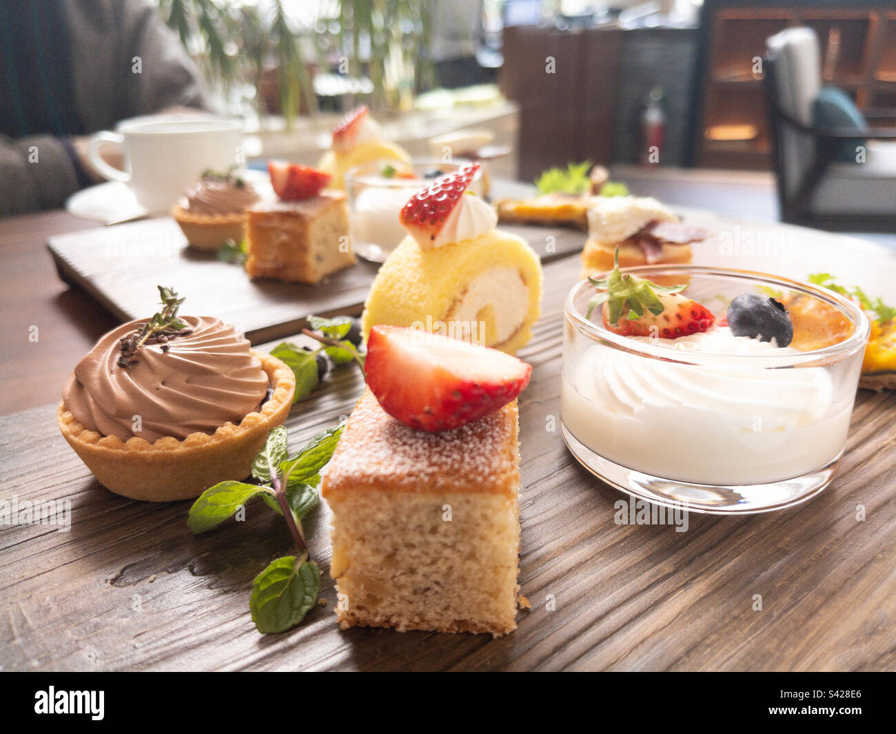Tè pomeridiano con torte e drink nel ristorante dell'hotel. Sfondo sfocato. - Immagine stock catturata con smartphone