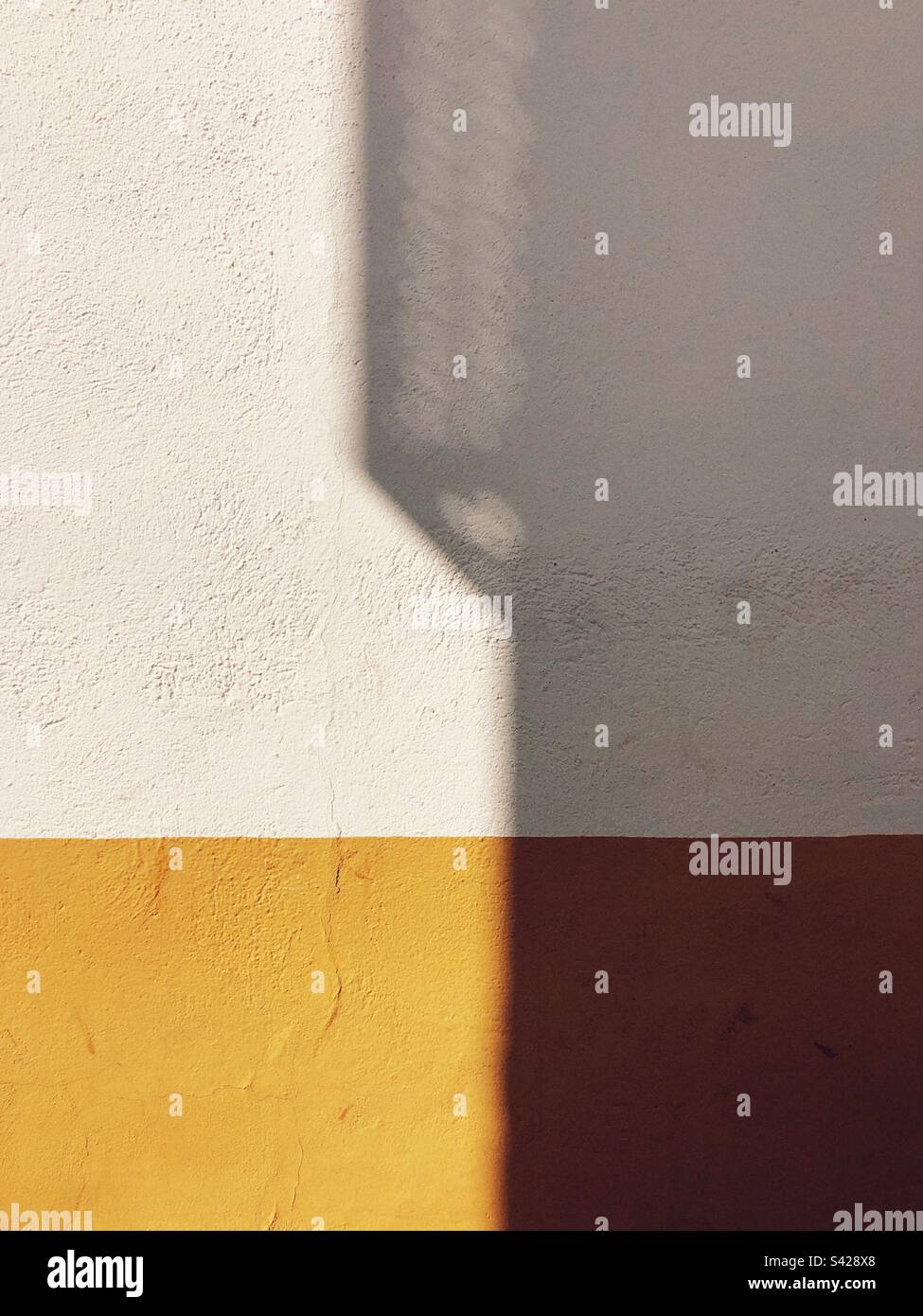 Composizione minimalista di una parete illuminata dal sole - Immagine stock catturata con smartphone