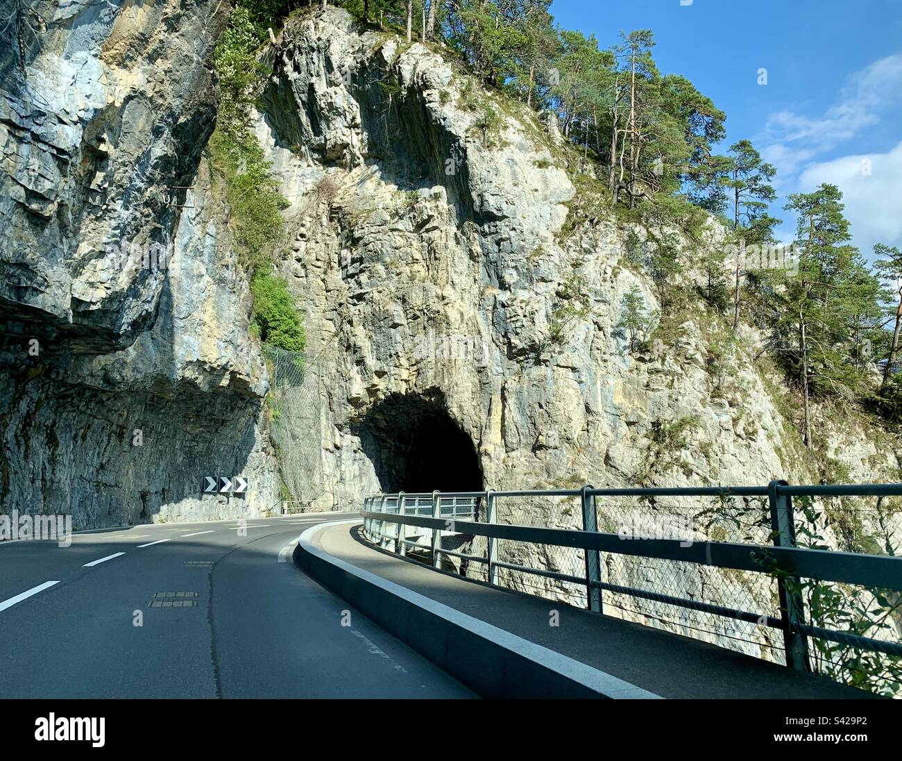 Strada in Svizzera che conduce al tunnel di montagna - Immagine stock catturata con smartphone