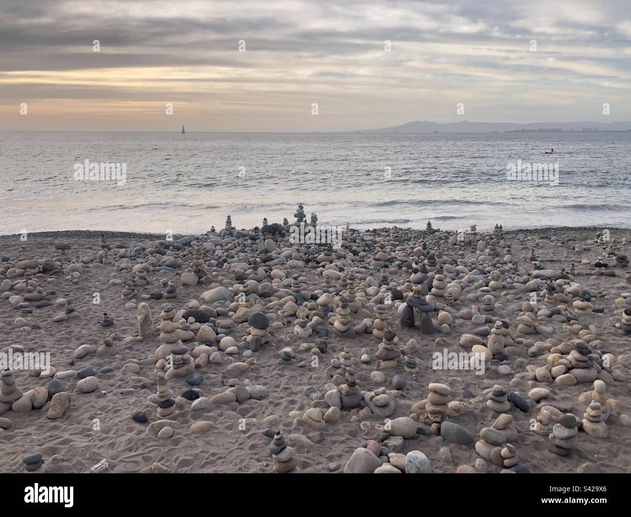 Una spiaggia piena di sculture in pietra equilibrante. Foto Stock