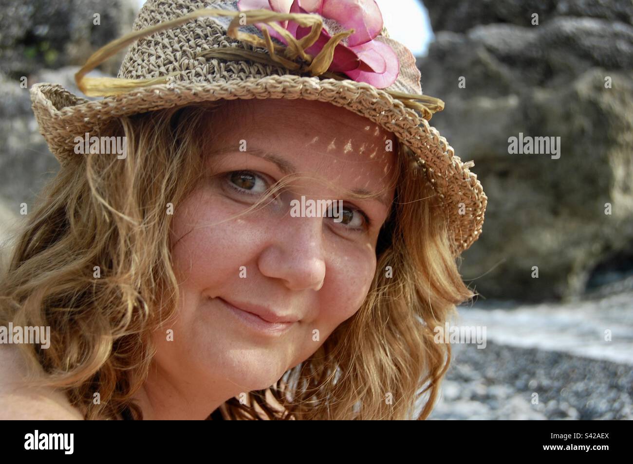 Bella donna bionda joung indossare un cappello di paglia sulla spiaggia in estate Foto Stock