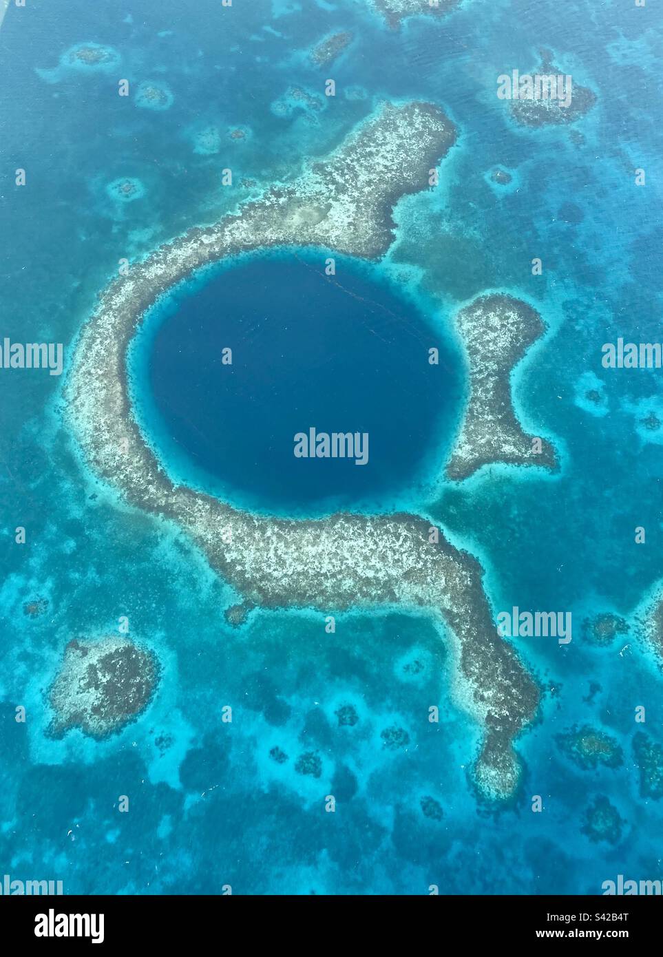 La vista aerea del bellissimo Great Blue Hole è una gigantesca sinkhole nel centro di Lighthouse Reef, parte del Belize Barrier Reef Reserve System Foto Stock