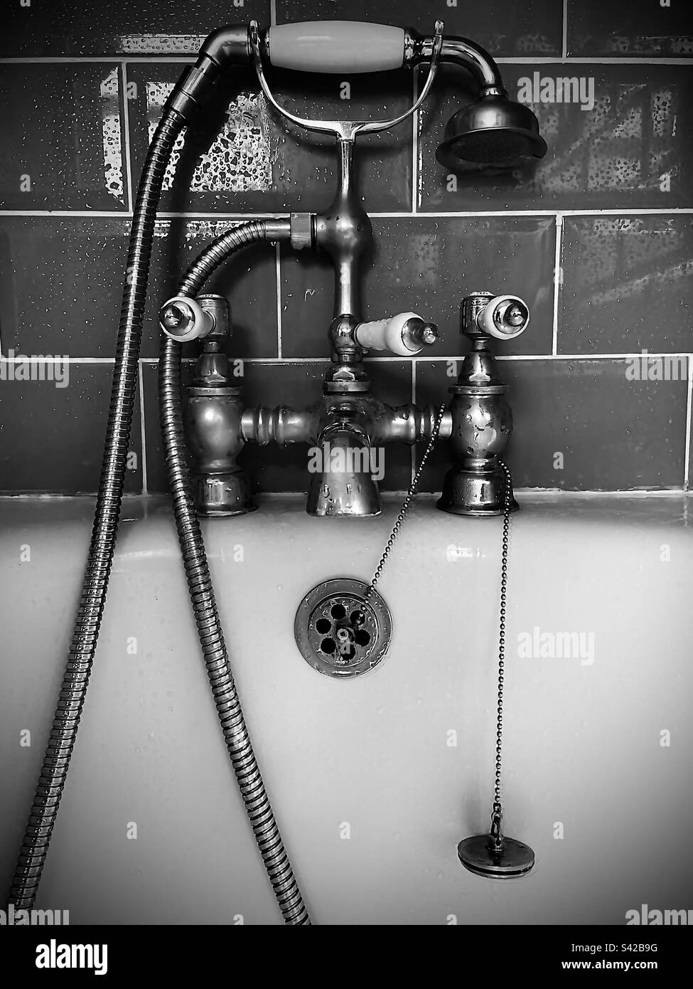 Bagno in stile vittoriano con rubinetto e tubo doccia e soffione in bianco e nero Foto Stock