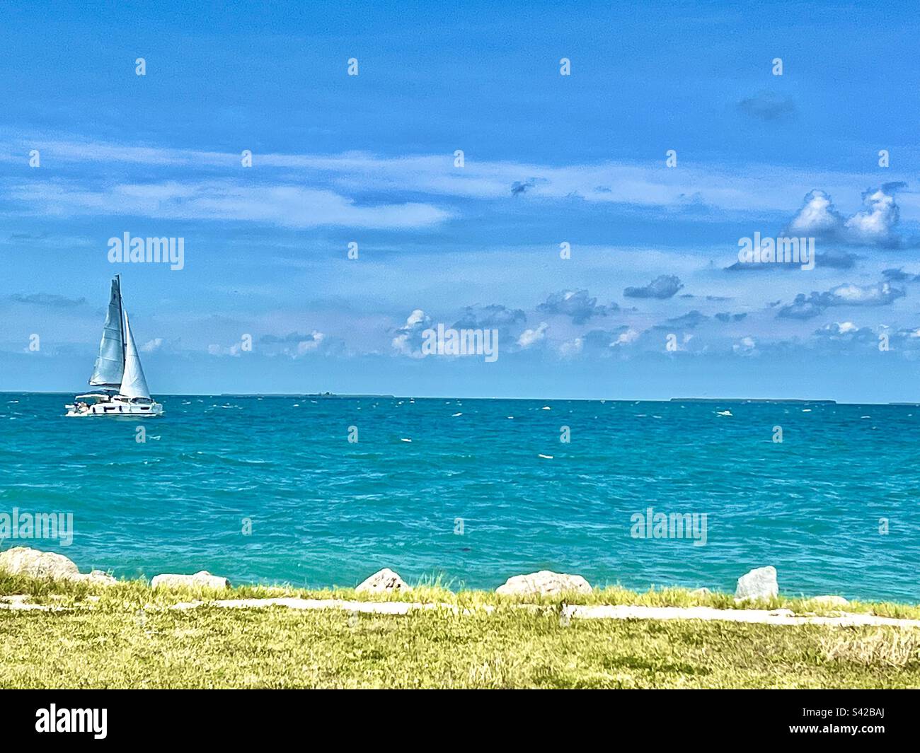Una barca a vela in una sola barca nelle acque blu al largo di Key West, Florida, nel mese di settembre Foto Stock