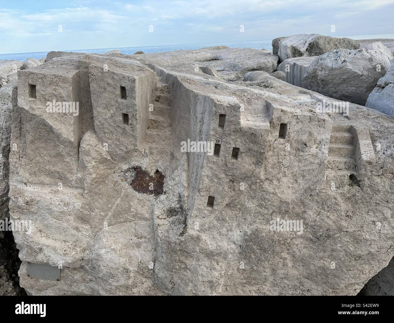 Villaggio di pietra scolpito su una roccia Foto Stock