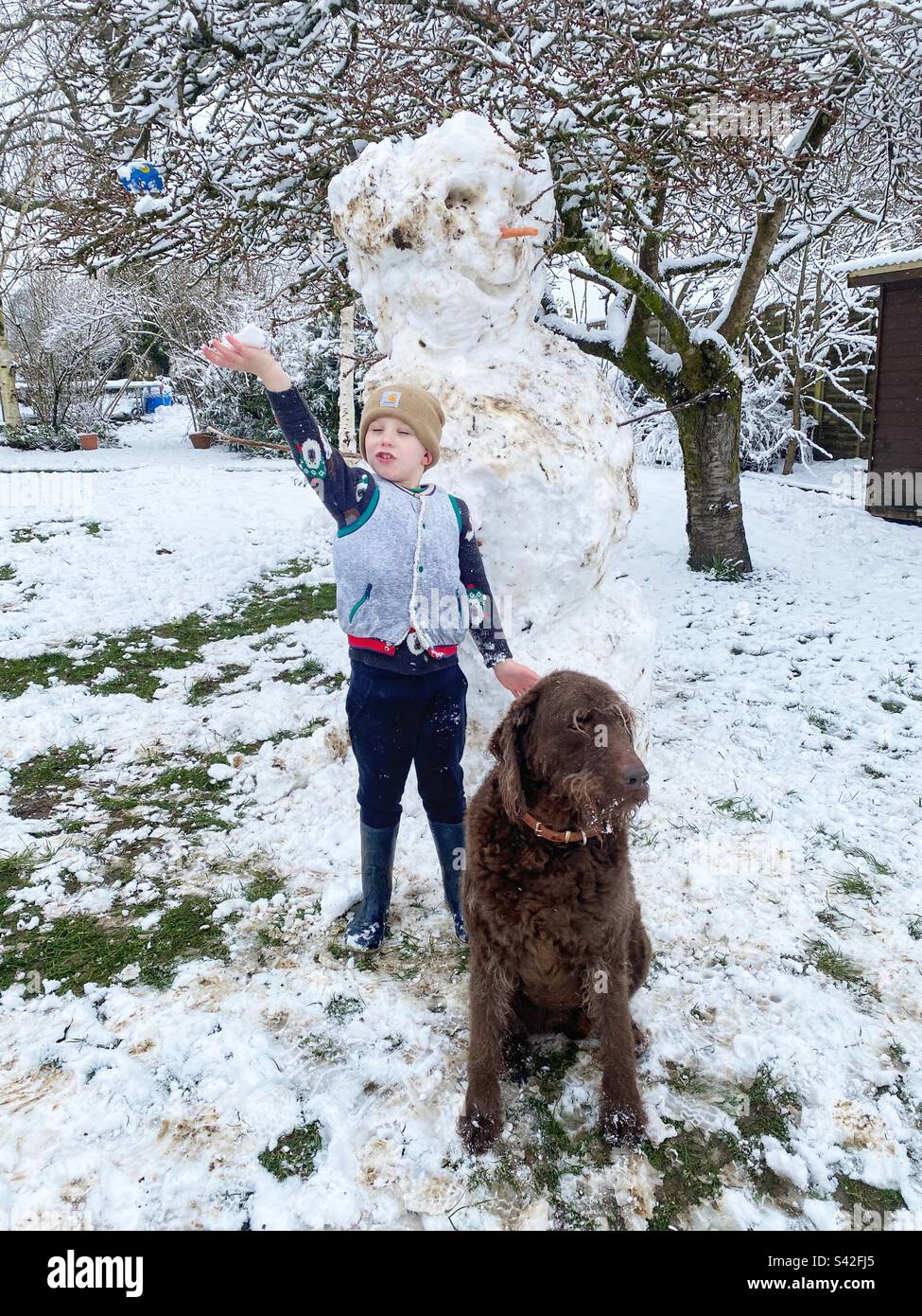 Ragazzo di sei anni che gioca nella neve, Hampshire, Inghilterra, Regno Unito. Foto Stock