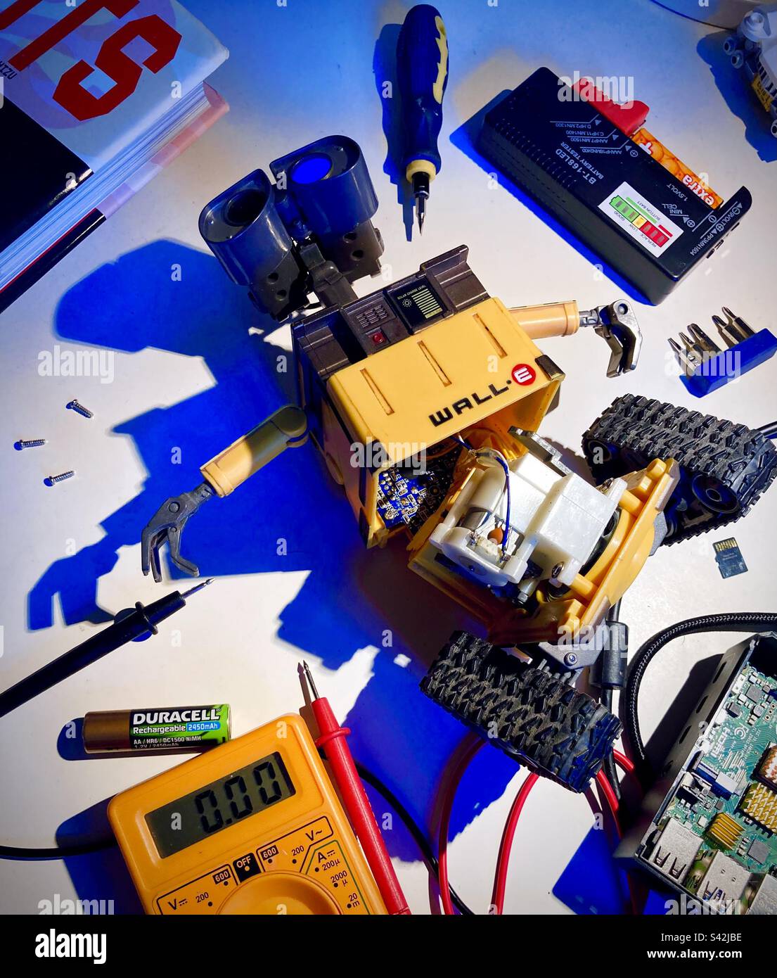 Fissaggio di un robot ELETTRONICO WALL-e giocattolo in un'officina di riparazione. Foto Stock