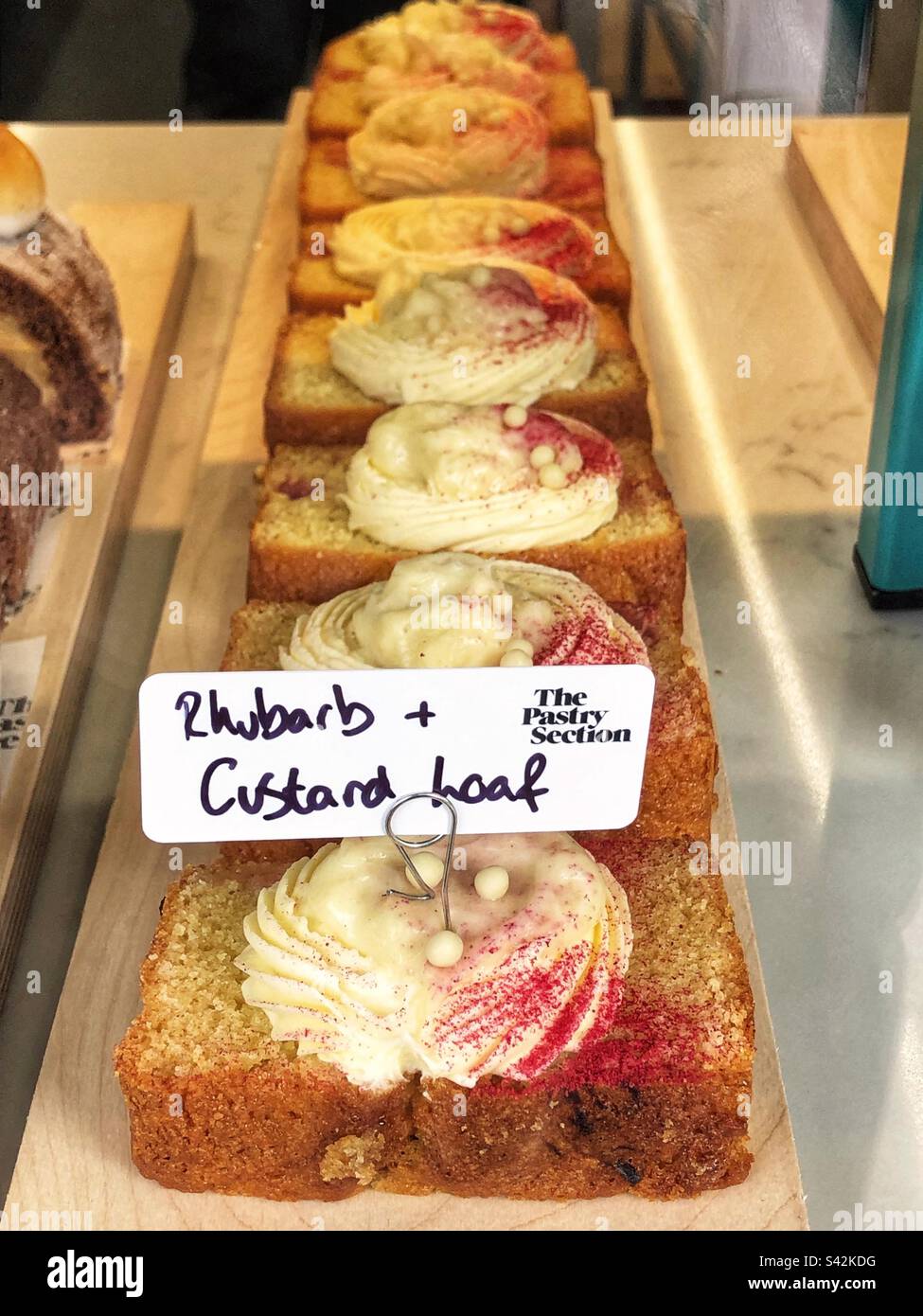 Rabarbarbaro e focaccia alla crema pasticcera nella vetrina del panificio Foto Stock