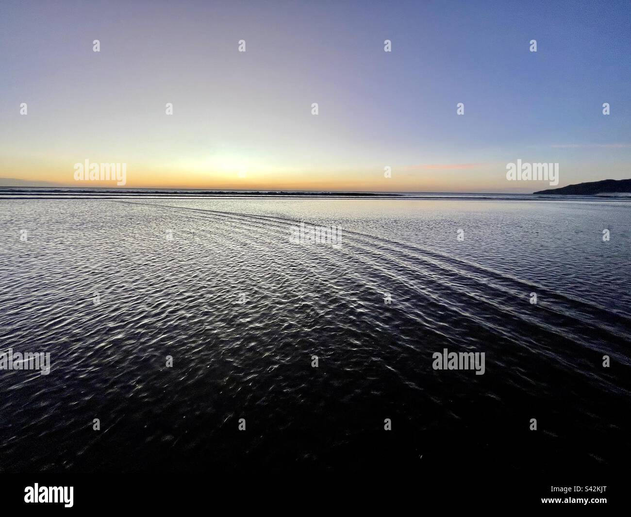 Tramonto sulla spiaggia con oceano tranquillo Foto Stock