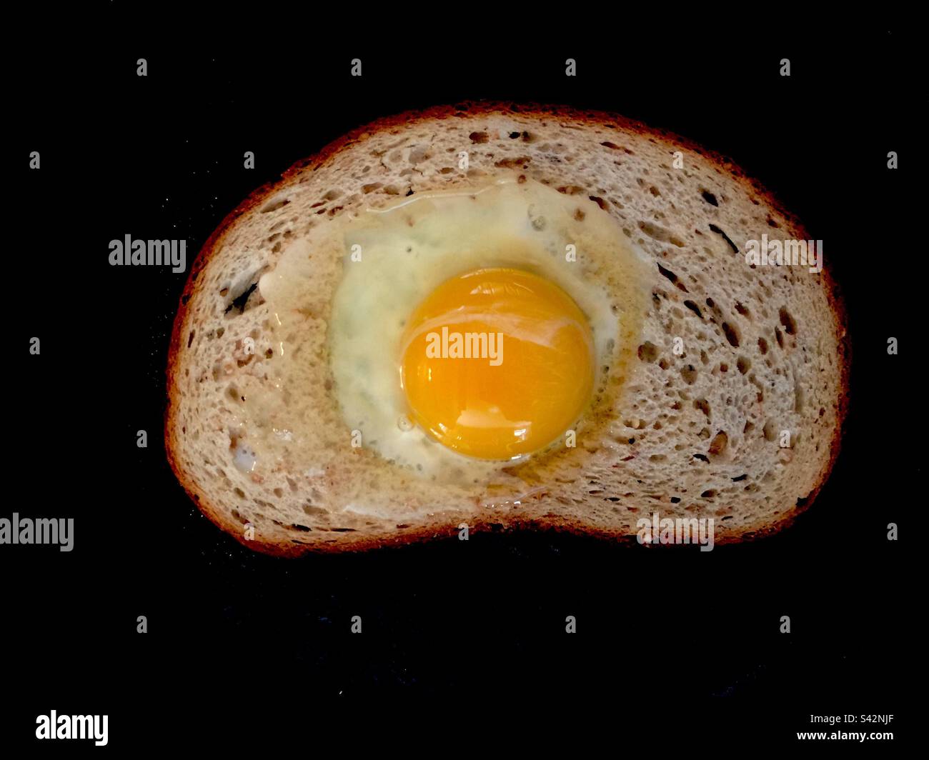 Uovo nel pane tostato. Il nostro pane quotidiano. Punta nel foro. Uova in un cestino. Uova cucinate in un foro tagliato in una fetta di pane. Foto Stock
