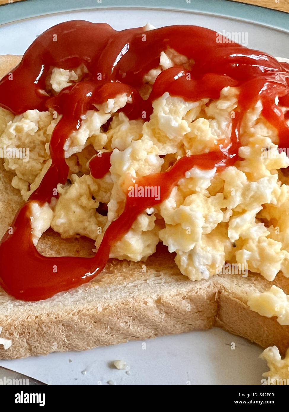 Uova strapazzate sul pane tostato con ketchup di pomodoro Foto Stock