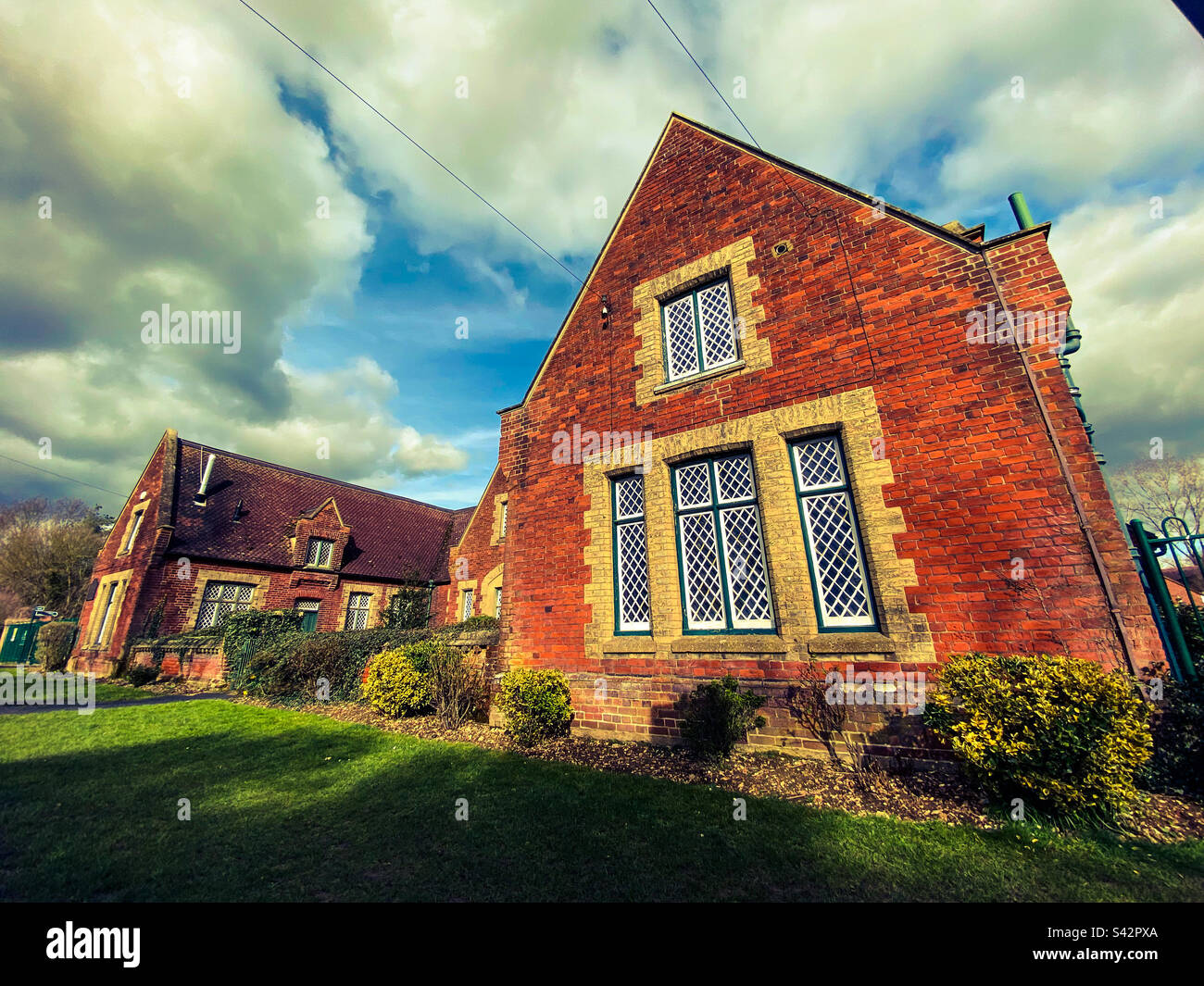 Un vecchio edificio scolastico tradizionale in un piccolo villaggio nella campagna inglese nel Regno Unito - Immagine stock catturata con smartphone