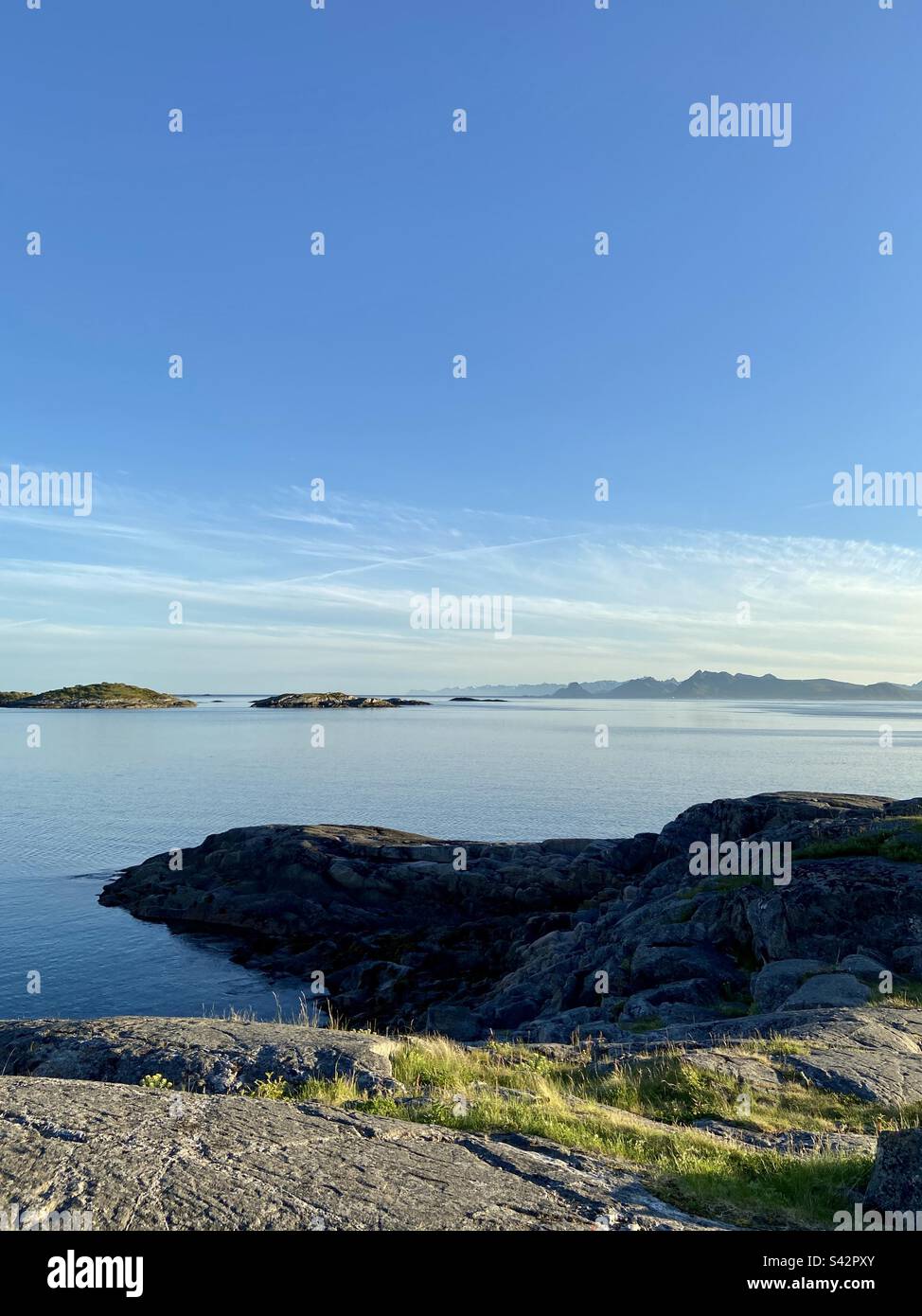 Paesaggio girato dal mare nelle isole Lofoten in una soleggiata serata estiva. Foto Stock