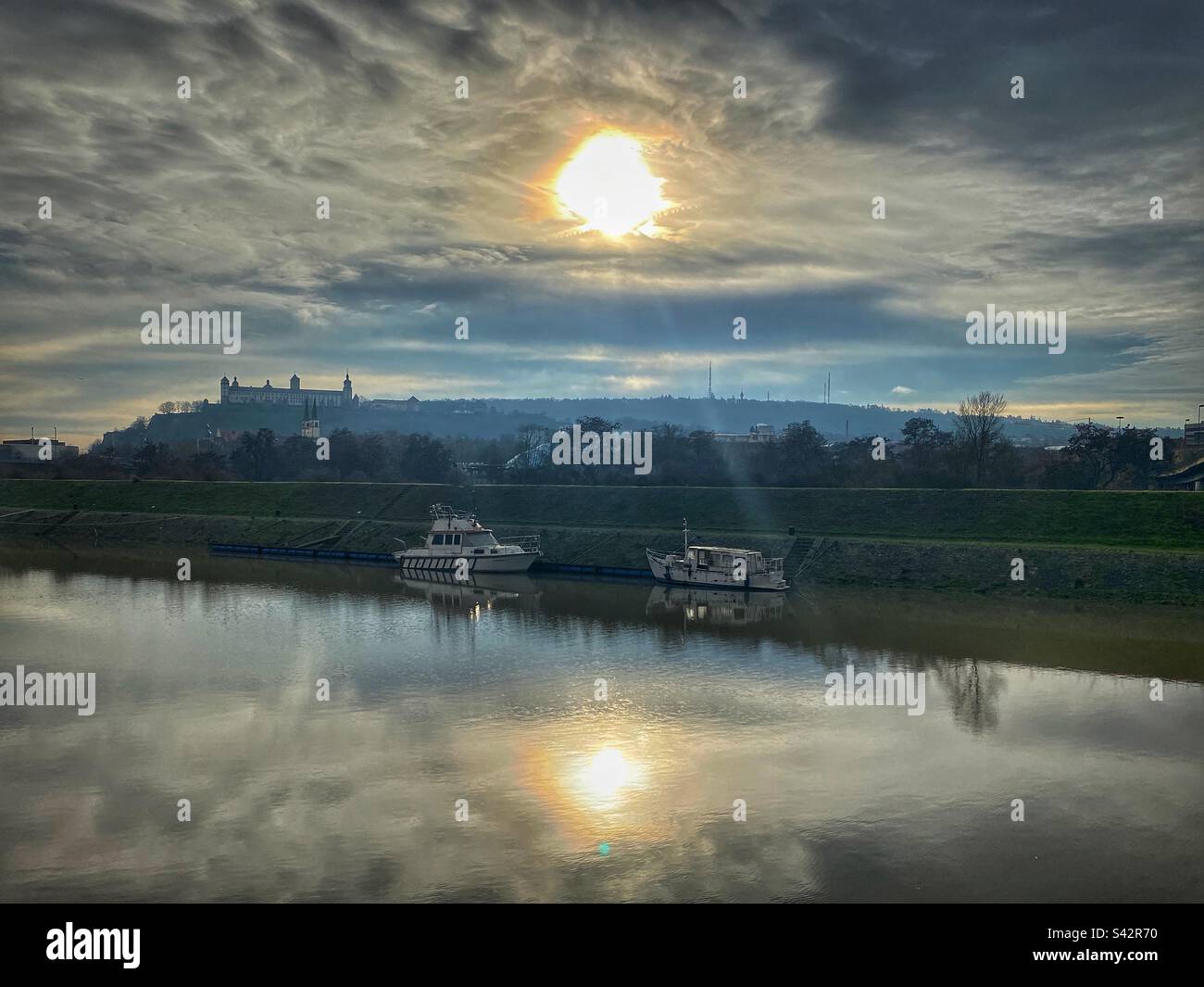 Barche sul fiume meno con vista sulla fortezza di Marienberg e tramonto a Würzburg, Germania. - Immagine stock catturata con smartphone