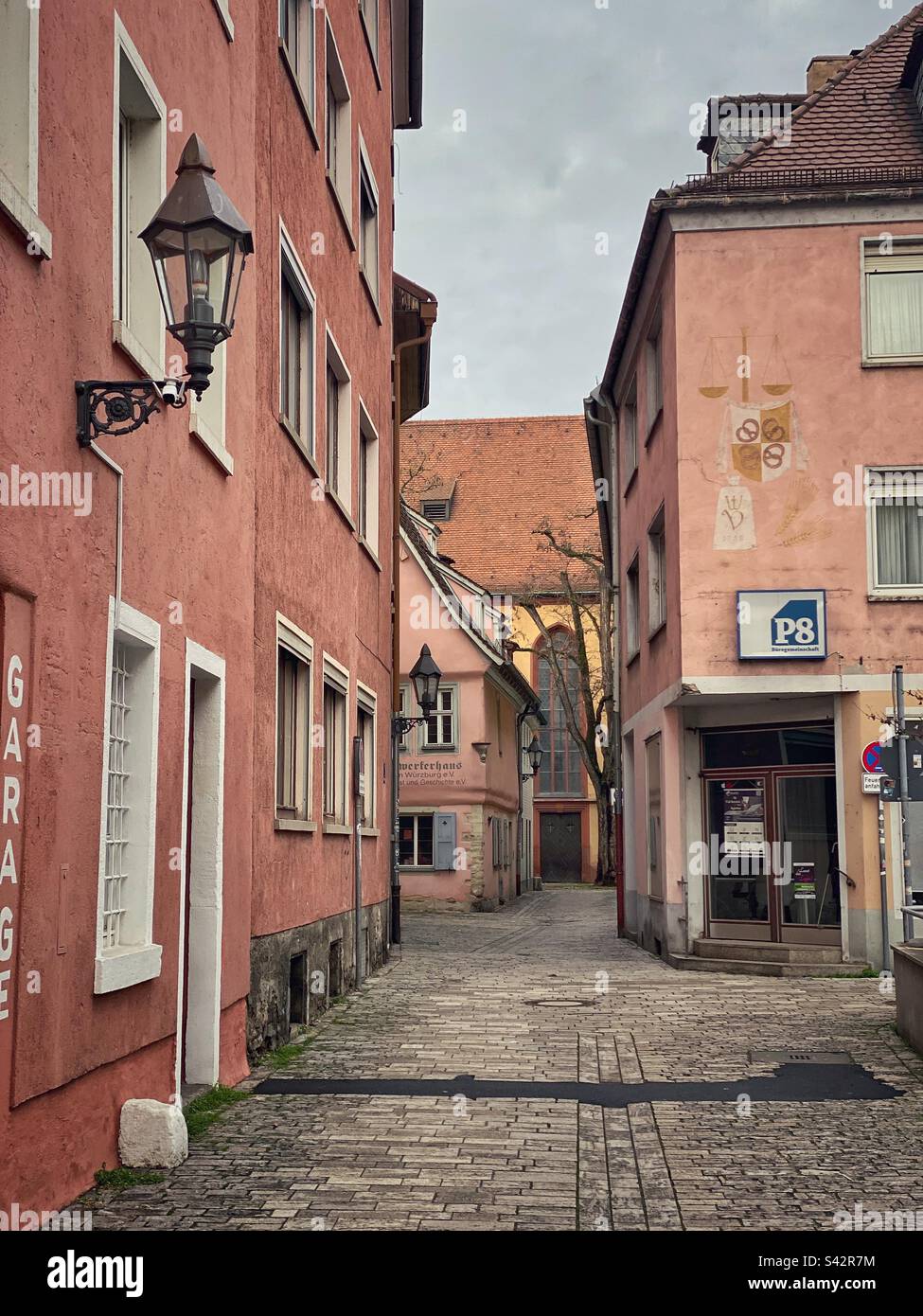 Vecchia strada stretta con case rosa nel centro di Würzburg, Germania. Foto Stock