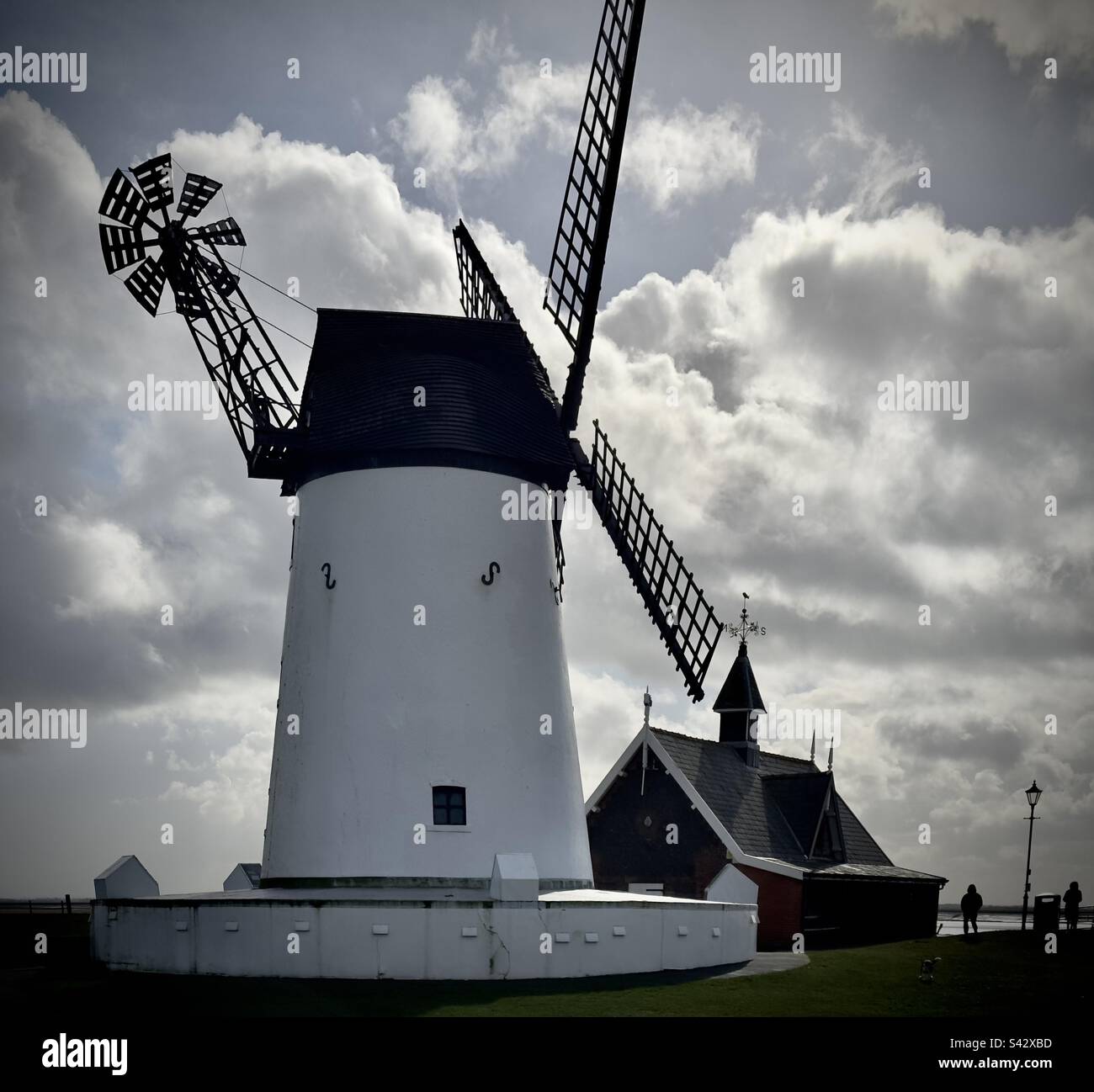 Il mulino a vento sul Lytham Green accanto alla casa della scialuppa di salvataggio, e di fronte a un suggestivo paesaggio - Immagine stock catturata con smartphone