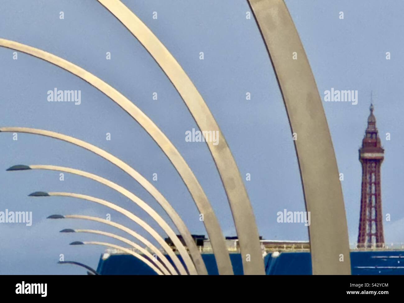Una serie di lampade curve standard lungo il lungomare di Blackpool, con la Blackpool Tower in lontananza. - Immagine stock catturata con smartphone