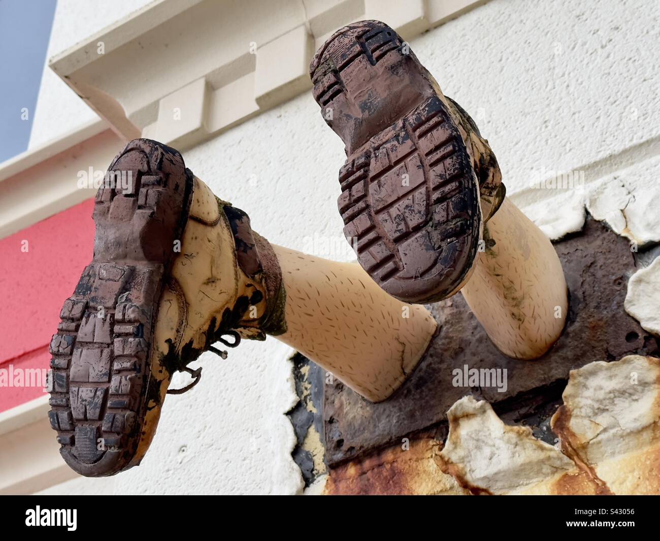 Un paio di gambe in scarpe da passeggio, apparentemente fuori dalla parete di un'attrazione sul mare a Blackpool. Stravagante e surreale! Foto Stock