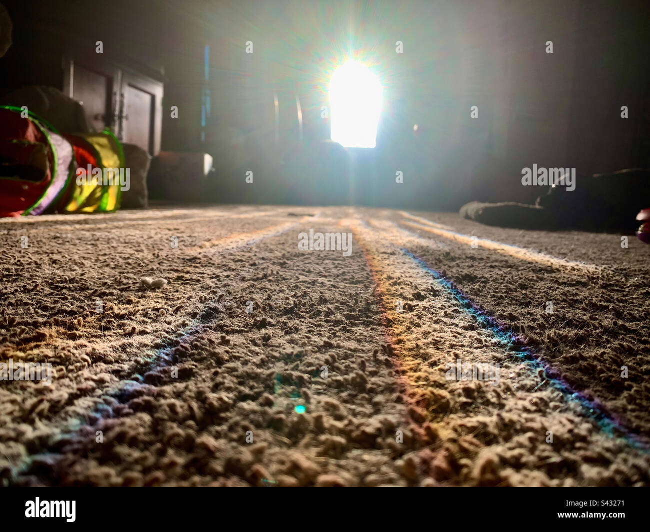 Luce arcobaleno diffusa sul tappeto dall'ingresso Foto Stock