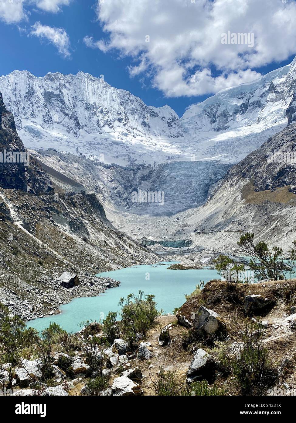 Il bellissimo lago glaciale di Laguna Llacca Huaraz Perù con acqua limpida blu scintillante e uno sfondo di cime innevate - Immagine stock catturata con smartphone