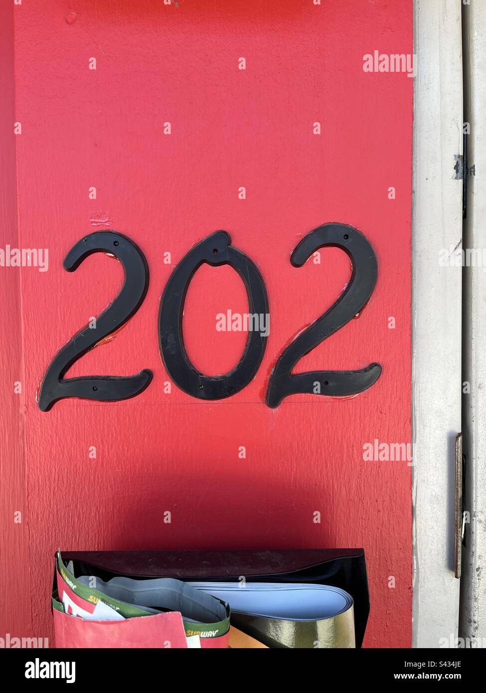 Esterno dell'edificio rosso con l'indirizzo 202 - Immagine stock catturata con smartphone