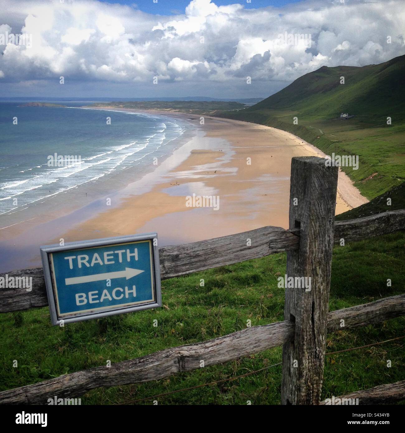 Un cartello in lingua gallese per la spiaggia che si affaccia sulla splendida Gower Coast Path si affaccia sulla splendida spiaggia di Rhossili sulla Gower Coast del Galles occidentale Foto Stock