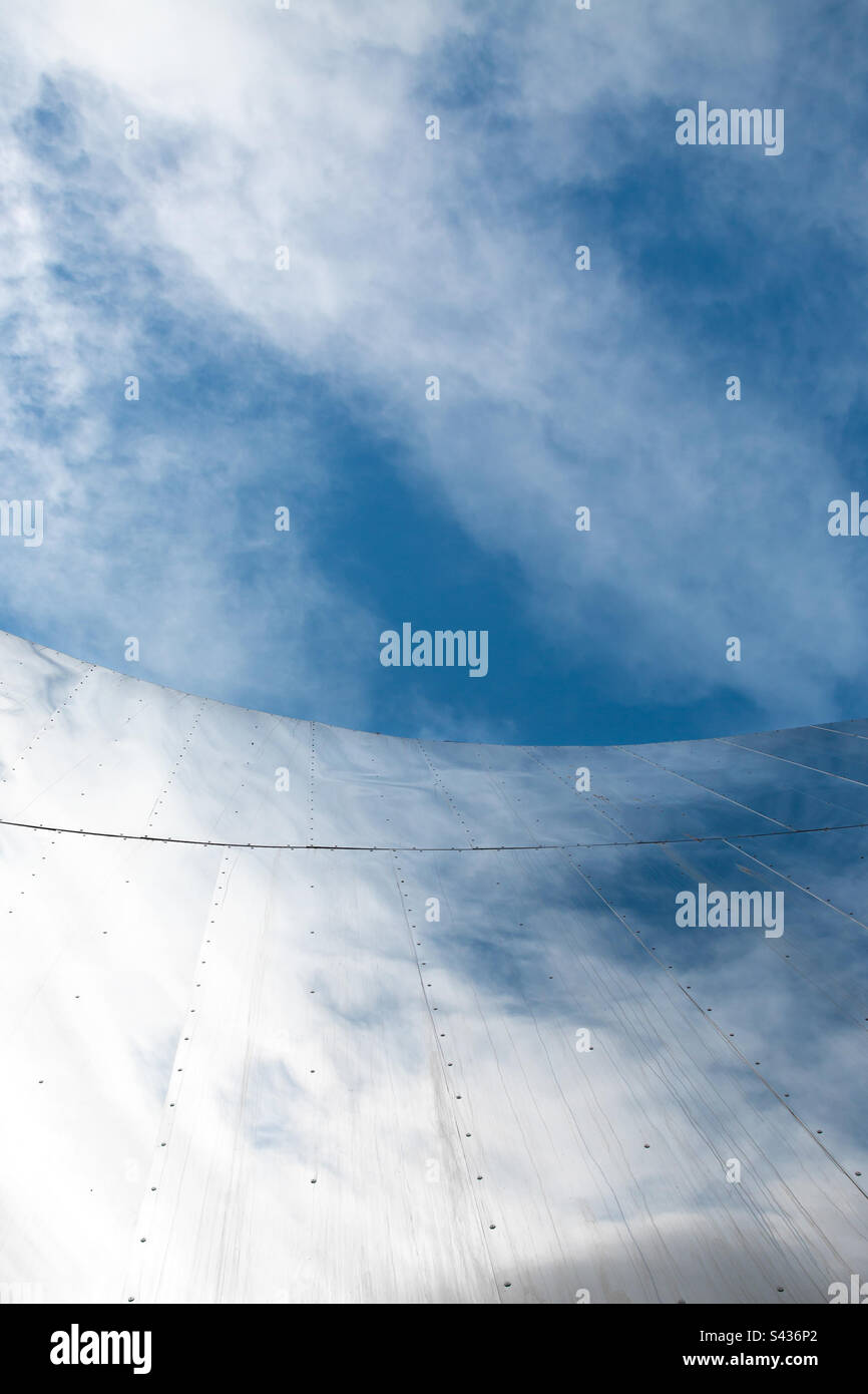 Architettura minimalista con facciata ricurva e riflessi di un cielo blu con spazio copia - Immagine stock catturata con smartphone