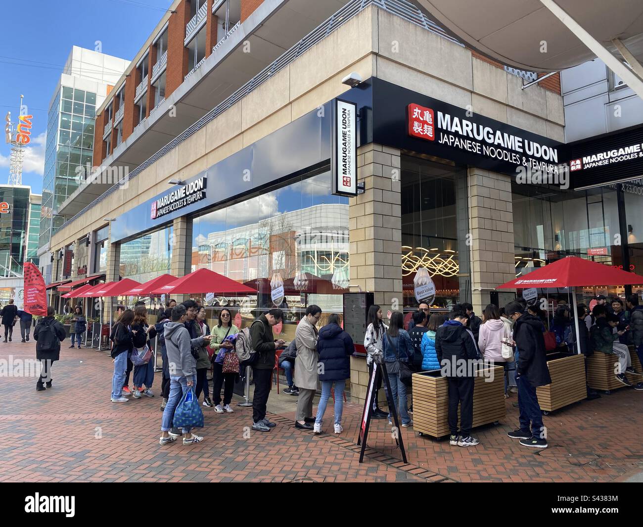 Una lunga coda per andare all'interno del ristorante giapponese Marugame Udon di recente apertura a Reading, Regno Unito Foto Stock