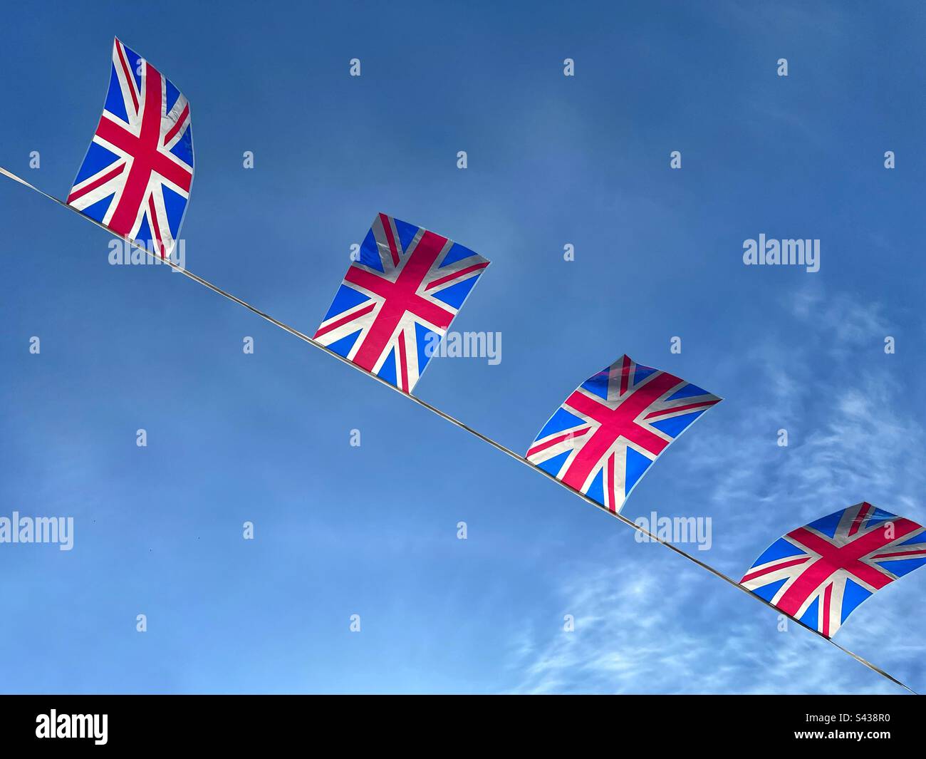 Union Jack bandiere contro il cielo blu Foto Stock