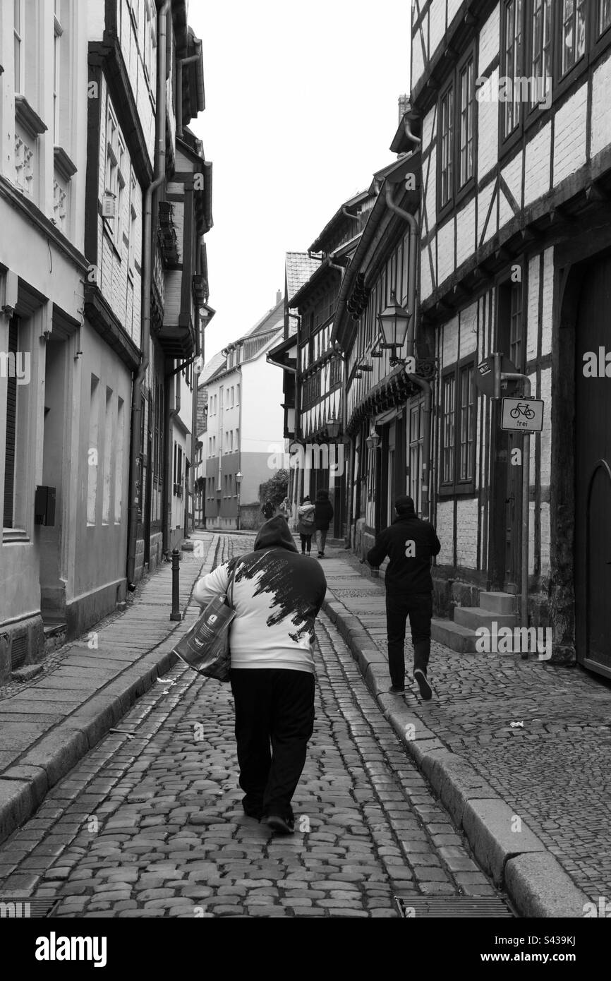 2 uomini che camminano per piccole strade della Germania orientale. Foto Stock