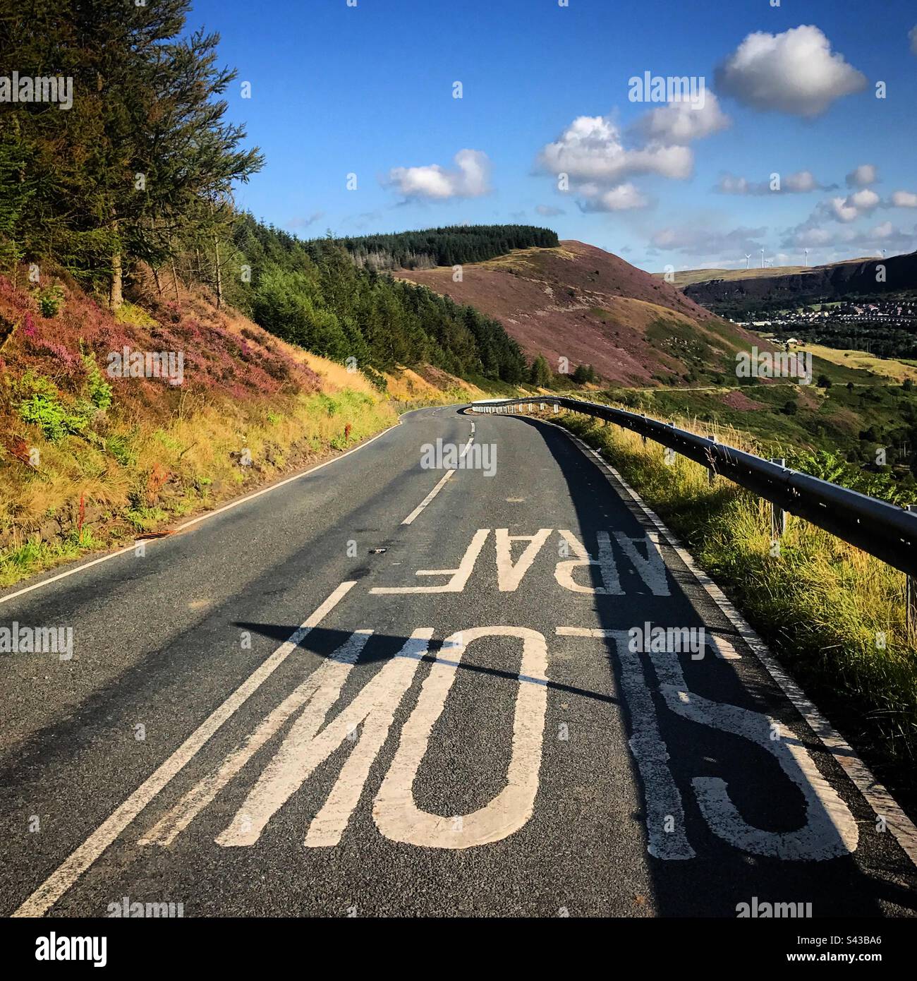 La drammatica strada di montagna A4223 nel Valley di Rhondda in Galles tra Maerdy e Aberdare con LENTO scritto bilingue in gallese e in inglese Foto Stock