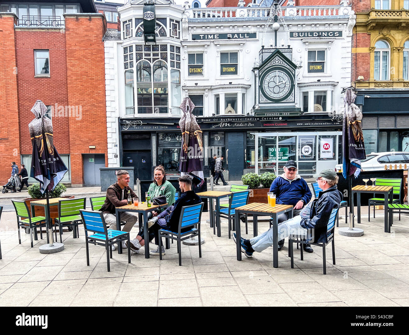 Persone che bevono e che si divertono al di fuori degli edifici Time Ball un edificio classificato di grado 2 nel centro di Briggate Leeds 1865 Foto Stock