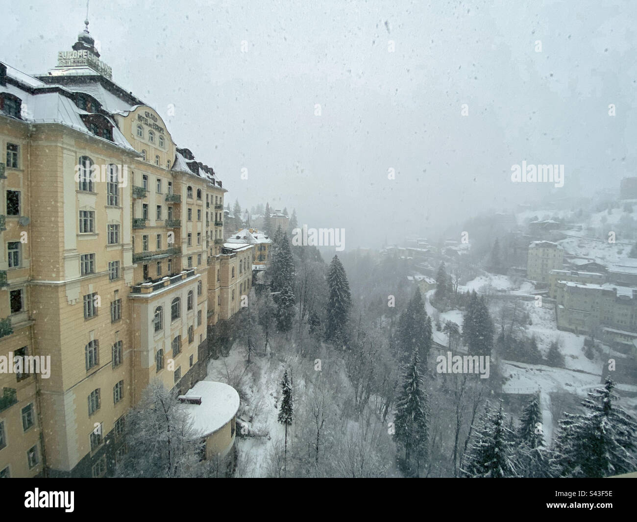 Bad Gastein, Salzburgerland, Austria - Dicembre 2020. Vista sullo storico Grand Hotel de l’Europe e parte del piccolo villaggio di Bad Gastein durante una nevicata invernale. - Immagine stock catturata con smartphone