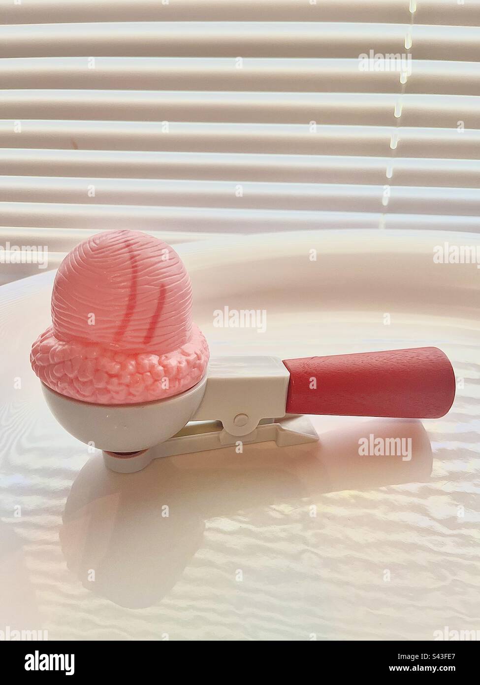 Fingere di giocare con la paletta per gelato alla fragola. Foto Stock
