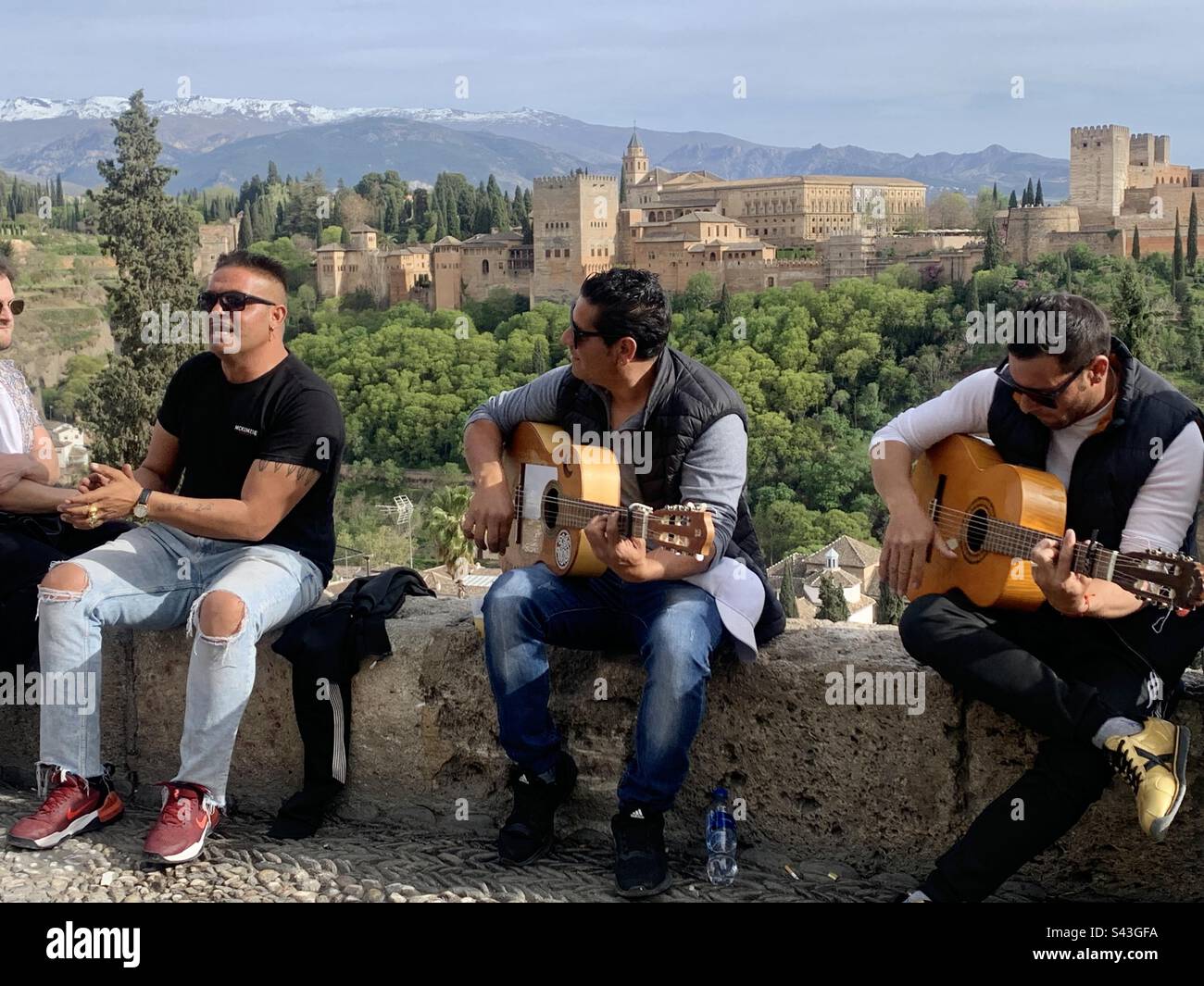 Musicisti che suonano musica con l'Alhambra in sottofondo - Immagine stock catturata con smartphone