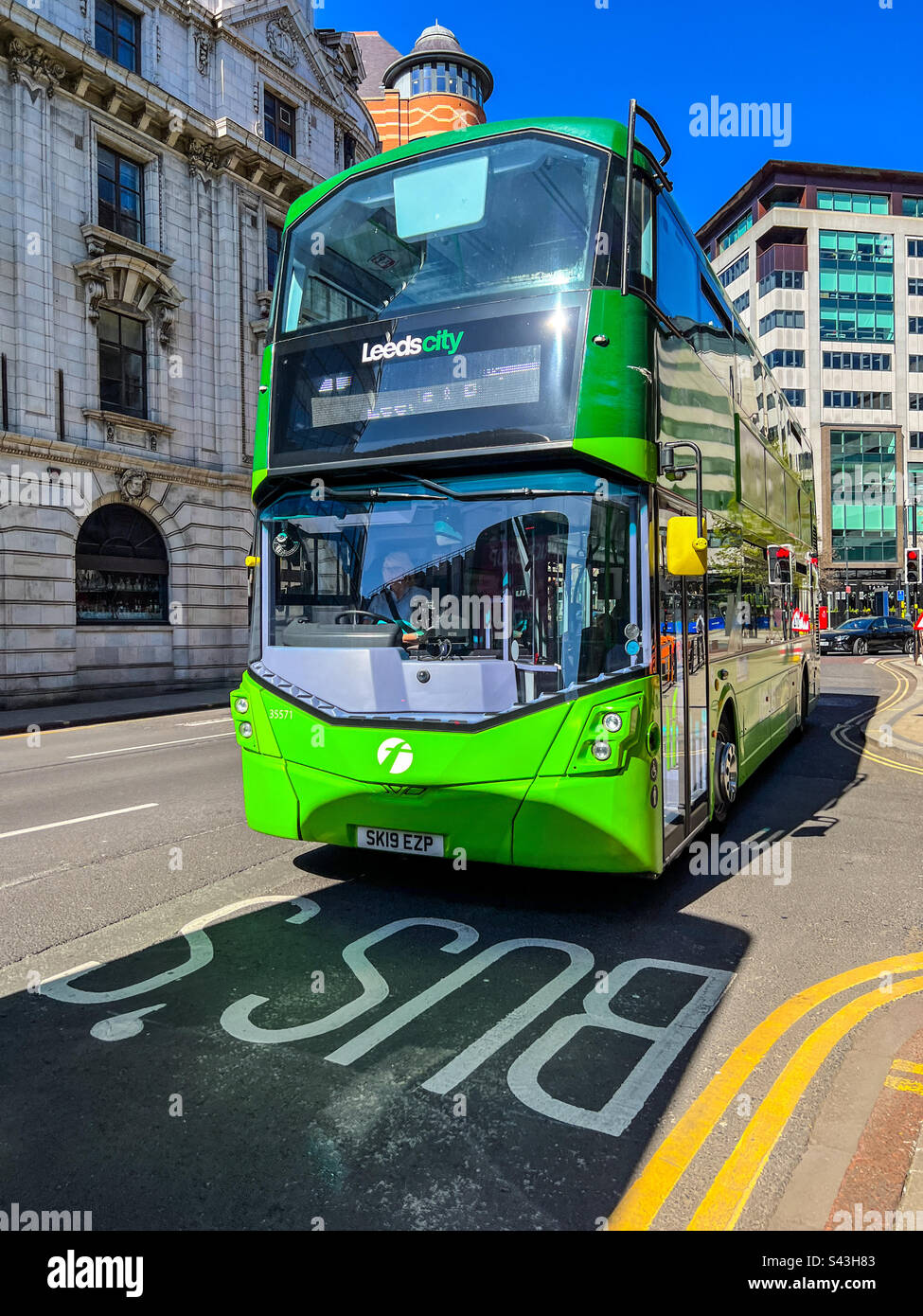 Autobus verde che guida nella corsia degli autobus nel centro di Leeds Foto Stock