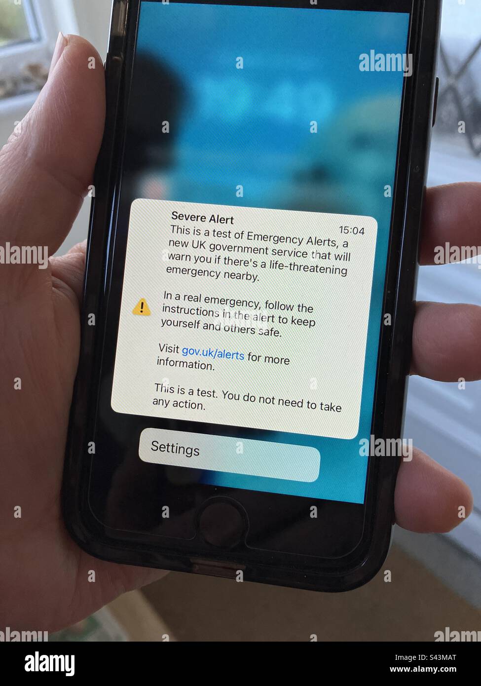Telefono cellulare in mano con SMS. Avviso grave, un test del governo britannico inviato ai telefoni cellulari il 23rd aprile 2023. Foto Stock
