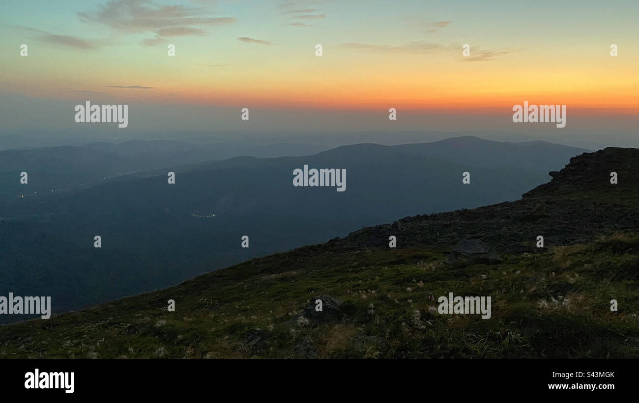 Montagne all'alba. Paesaggio naturale di montagna con cime nebbie illuminate, pendici e valli nebbie, cielo blu con luce solare gialla arancione. Incredibile scena da Beskid Zywiecki in Polonia - Immagine stock catturata con smartphone