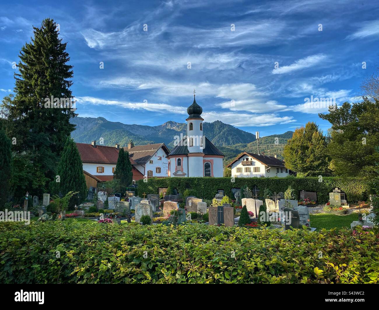 Tradizionale chiesa bavarese e cimitero con vista sulle Alpi a Schlehdorf vicino al lago Kochelsee, Germania. Foto Stock