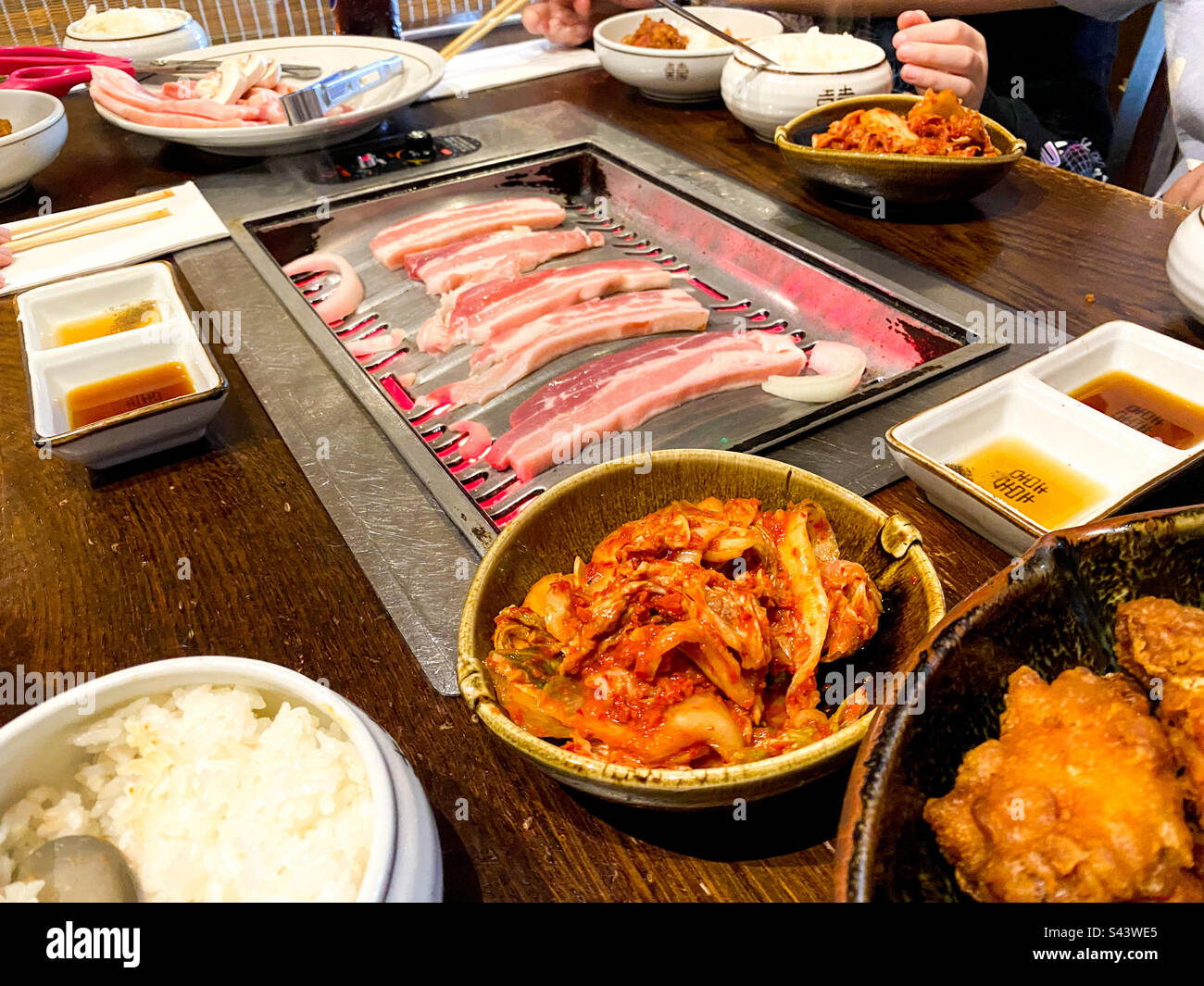 Barbecue coreano con cucina di maiale alla pancia alla griglia in un ristorante coreano. - Immagine stock catturata con smartphone