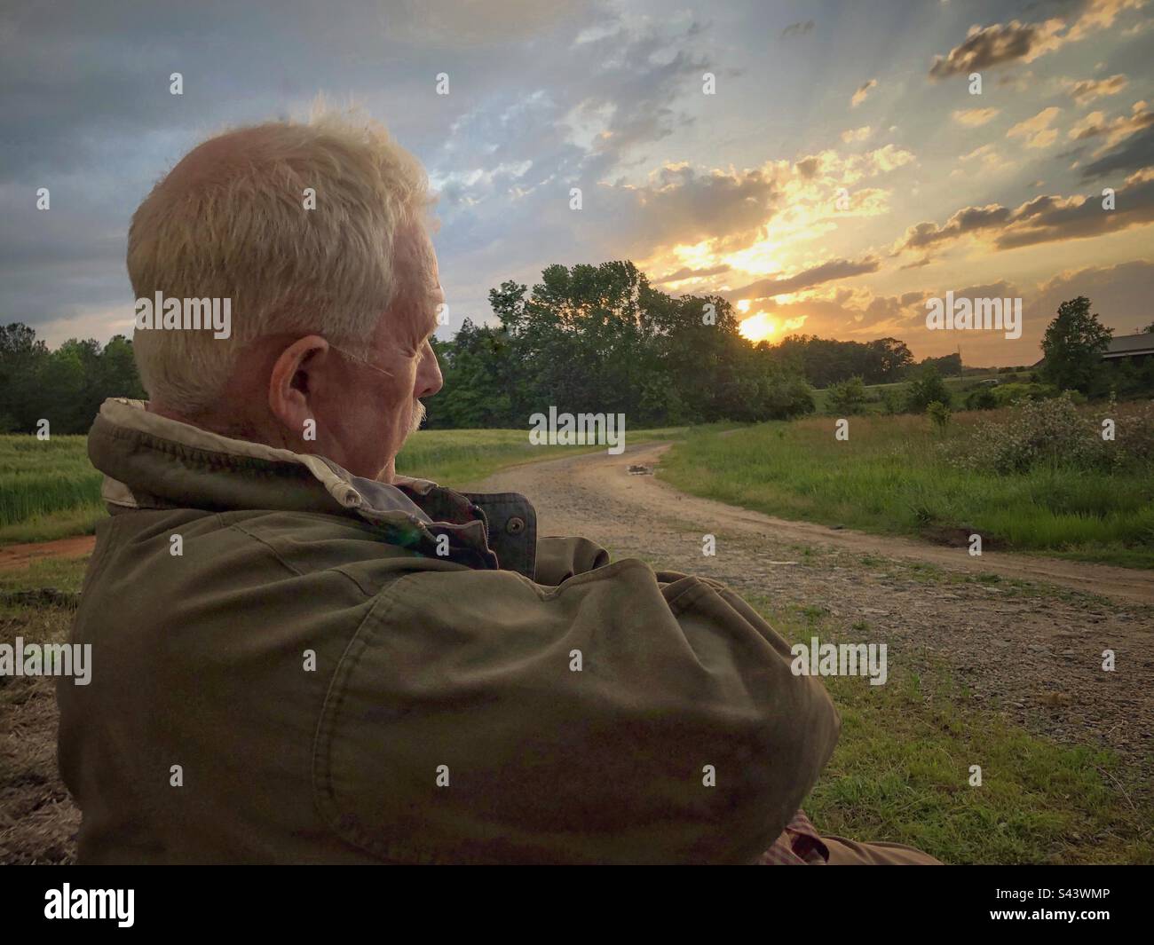 Guardando il tramonto lungo un lungo vialetto in fattoria con l'uomo anziano, il mio amore Foto Stock