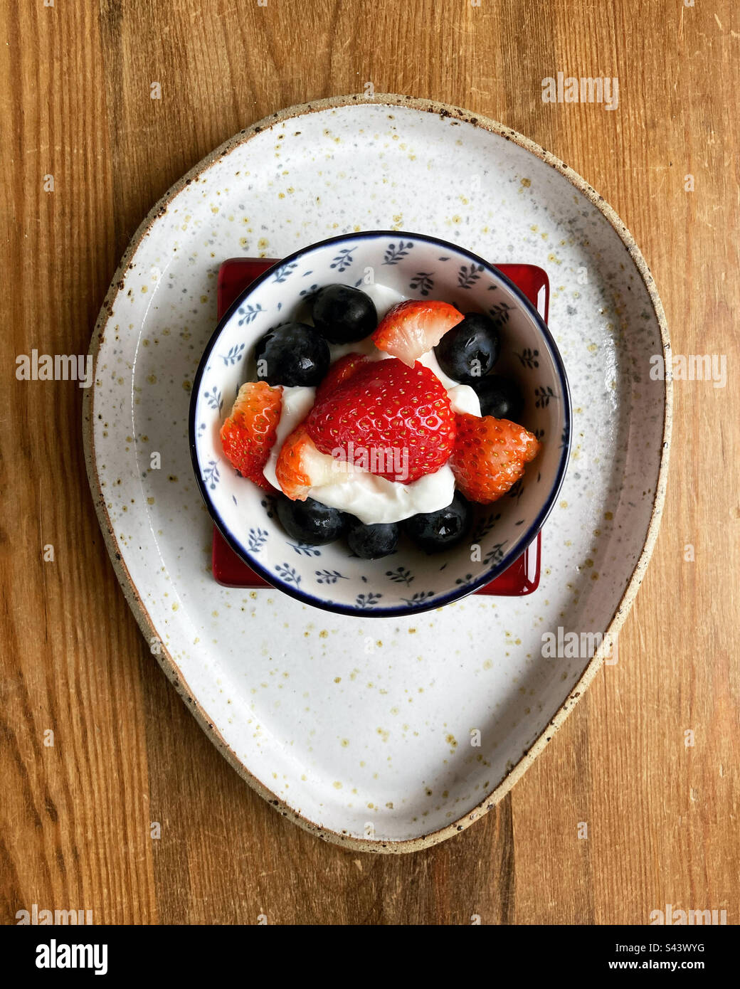 Ciotola di frutta morbida con yogurt in un piatto - Immagine stock catturata con smartphone